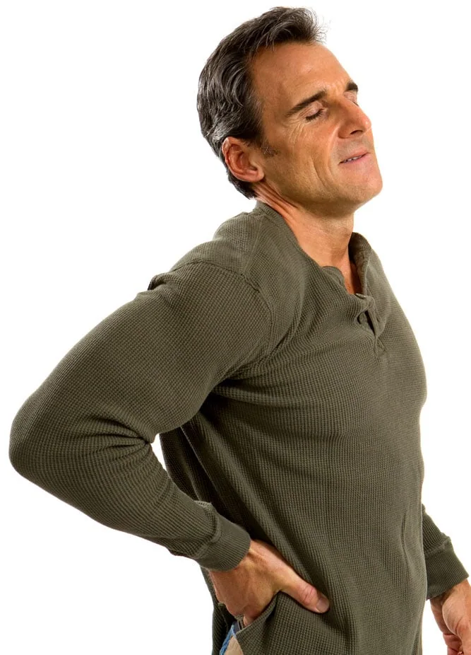 A man wincing with both hands on his lower back