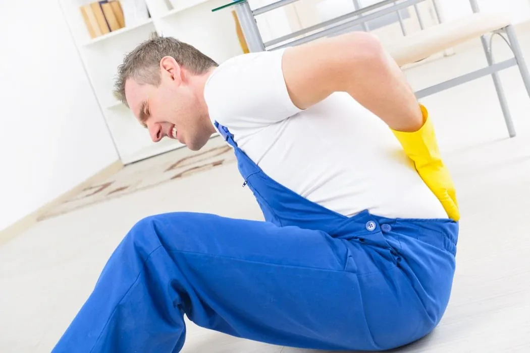 A worker holding their shoulder in pain after a workplace injury